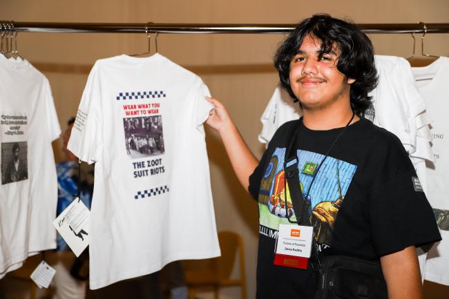 Student artist holding his artwork on a T-shirt