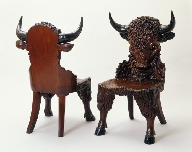 Two chairs with sculpted bison heads on their backs