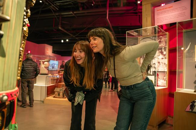 two young women looking at a pieces of art in the museum 