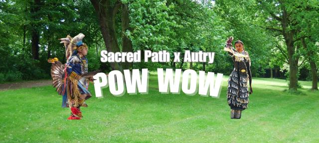 Two Native American dancers in traditional regalia stand on green grass in a park with trees. Bold white text reads "Sacred Path x Autry POW WOW" across the center of the image.