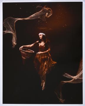 A woman in a brown outfit floats underwater, holding a woven basket. Fishing nets drift around her in the dark, ethereal scene.