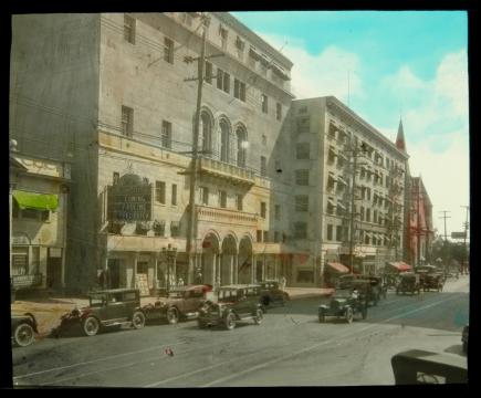 downtown street scene with buildings and early cars