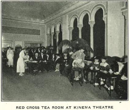 women being served tea in large room with arched doorways with columns