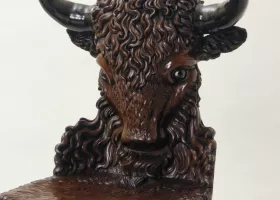 two wood chairs with backs carved as buffalo heads