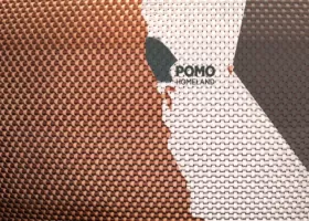 closeup of woven basket with outlines of a map and a shaded-in area within the state of California labeled "POMO HOMELAND"