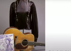 black satin shirt on mannequin with guitar and sheet music