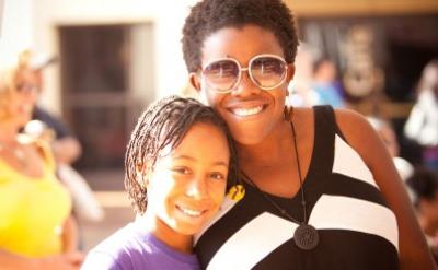a smiling woman and young girl standing close together