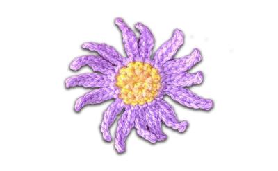 crochet daisy made of purple yarn with a bright yellow center