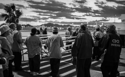 A group of inmates gather at sunrise