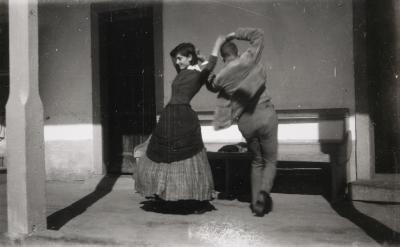 man and woman dancing mid-twirl with arms above and back to back