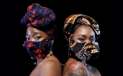 two african-american women in masks with a look of confidence pose with bare shoulders
