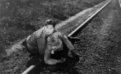 a man pulls a woman away from a train track
