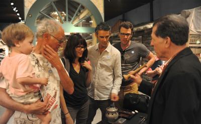 a museum guide demonstrates the use of some historic items a group of five people are watching the demonstration