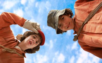 two boys in orange looking down at camera