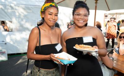 Two young women smiling with food
