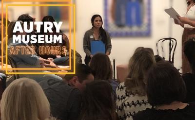 A group of people are seated and attentively listening to a speaker in an art gallery. The speaker is standing, holding papers. The text "Autry Museum After Hours" is displayed on the left side of the image. Paintings hang on the wall in the background.