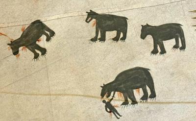 A drawing shows four black bear-like animals with red markings, one of which is biting a human figure. The animals and human appear on a beige background, likely part of an ancient or indigenous artwork.