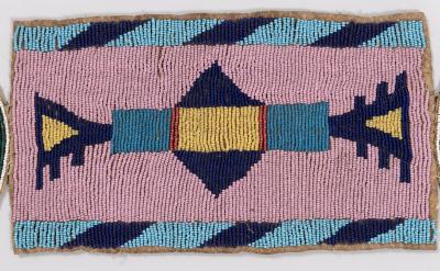 Rectangular beaded strip with geometric patterns in blue, dark blue, yellow, and red beads on a pink background; diagonal blue and dark blue bands border the top and bottom edges.