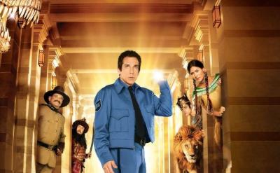 A security guard in a blue uniform stands in a museum hallway, looking surprised. Historical characters, a lion, and a T. rex head surround him, with golden light shining from behind.