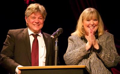Happy man and woman stand at podium