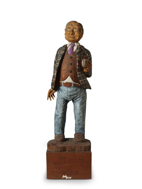 a sculpture of a white man done in the style of "cigar store" indians
