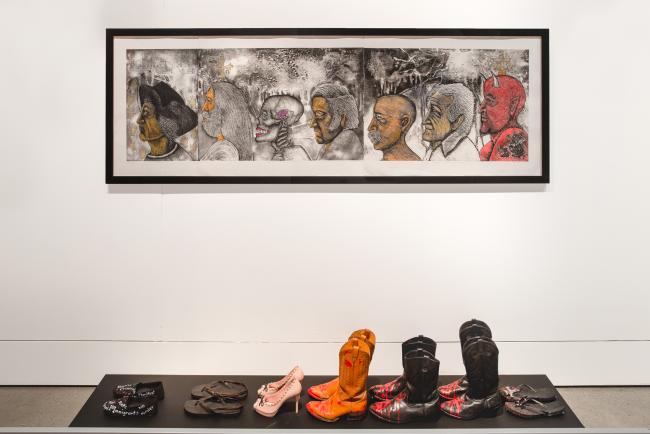 a painting with seven pairs of shoes beneath