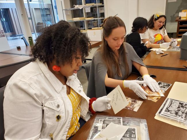 Students at library tables examining archival materials