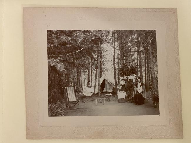 woman sitting in front of a tent in the woods