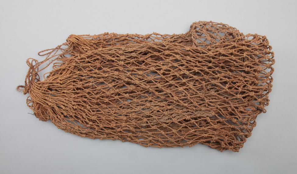 A loosely woven, brown string bag or net with an open mesh pattern, lying flat on a plain white background.