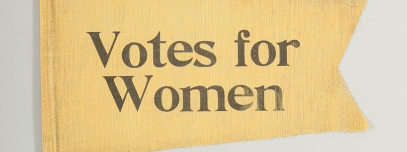 yellow flag with the words "Votes for Women" stenciled in black