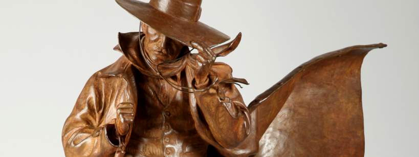sculpture of a cowboy tipping his hat down