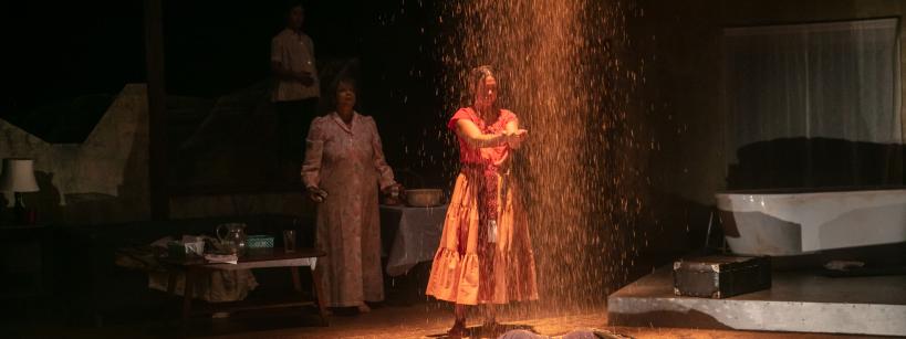 two women standing on stage performing in a play