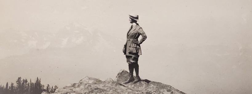 woman standing on a mountain peak