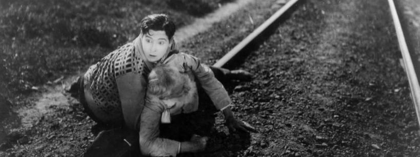 a man pulls a woman away from a train track