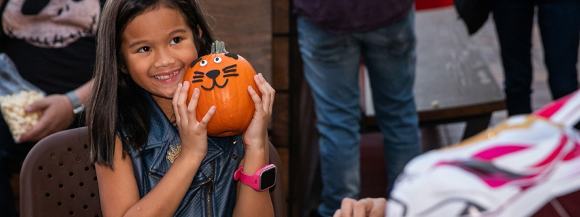 young girl holding a pumpkin