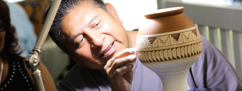Native artist working on ceramic vase