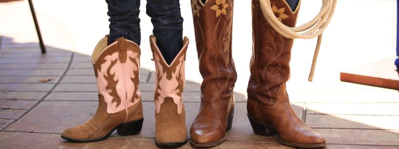 Close up of two children's cowboy boots and rope