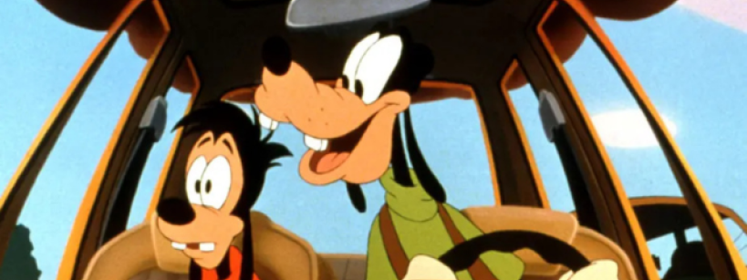 Animated characters, a tall dog in a green shirt and a smaller dog in a red shirt, are in a car. The tall one is driving and smiling, while the smaller one looks anxious. The view is from the front, showcasing a bright, cartoonish environment.