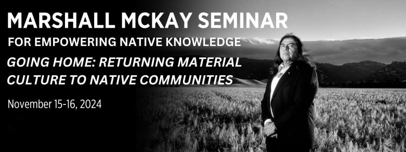 Black-and-white image of a long-haired person in a suit standing in a field with hills in the background. Text reads: "Marshall McKay Seminar for Empowering Native Knowledge: Going Home: Returning Material Culture to Native Communities. Nov 15-16, 2024.