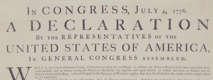 A close-up of the top portion of the United States Declaration of Independence, dated July 4, 1776, showing the title and introductory text in large, bold letters.